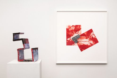 sculpture on table with abstract work on wall